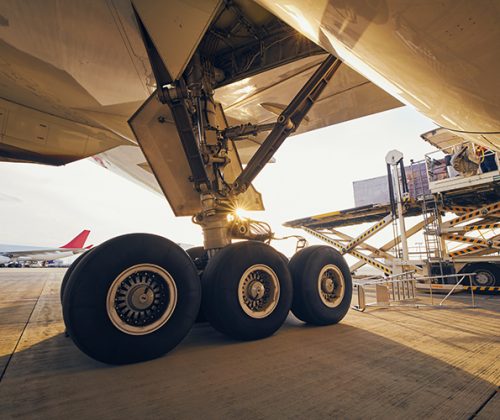 Preparation before flight. Loading of cargo containers to airplane at airport.